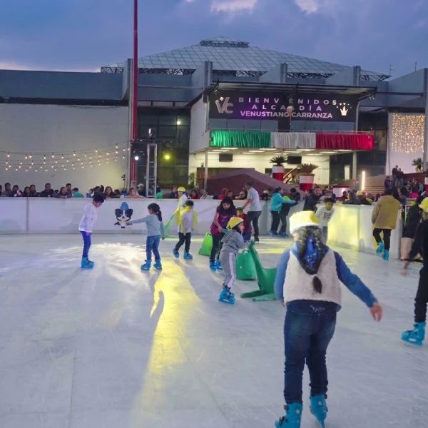 Familias y niños patinando en la pista ecológica durante el atardecer